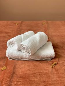 two white towels sitting on top of a bed at Hôtel Tête d'or in Lyon