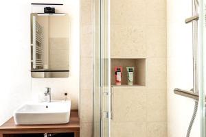 a bathroom with a sink and a shower at Hôtel Tête d'or in Lyon