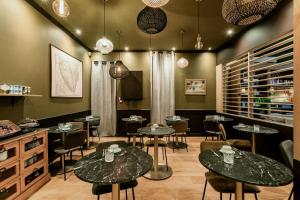 a restaurant with tables and chairs in a room at Hôtel Tête d'or in Lyon