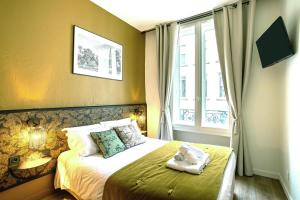 a bedroom with a bed with towels on it at Hôtel Tête d'or in Lyon