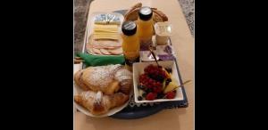 a tray of food with bread and a plate of fruit at Room in SPA " TABARKA " in Spa