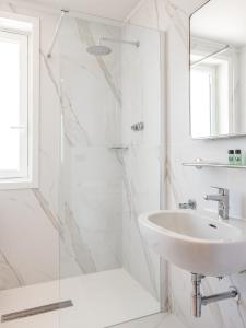 a white bathroom with a sink and a shower at Mirabella Hotel in Mirabella Eclano