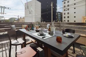 una mesa en un balcón con bebidas y comida. en Good Neighbors, en Kanazawa