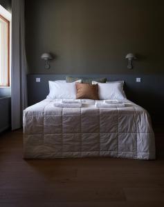 a bedroom with a large bed with white sheets and pillows at Hotelli Vihannonkulma in Loimaa