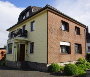ヒュルトゲンヴァルトにあるHaus mit Garten (neben National Park Eifel)のレンガ造りの家で、バルコニーが付いています。