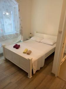 a bedroom with a white bed with two pillows on it at Apartmant Nik in Herceg-Novi