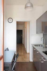 a kitchen with a counter and a clock on the wall at CASA KIKA Comoda, Luminosa e Accogliente in Milan