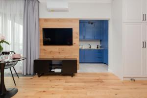 a kitchen with blue cabinets and a television on a wall at Łazienki Park Residence by Renters Prestige in Warsaw