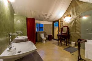 a bathroom with a sink and a toilet and a piano at Phelwana Game Lodge in Hoedspruit +106 photos