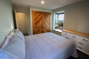 a bedroom with a large bed and a window at Roydons - Kaiteriteri Upstairs Holiday Unit in Kaiteriteri