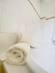 - une serviette assise sur le côté d'une baignoire dans l'établissement A DEUX PAS DE LA CATHEDRALE, à Laon