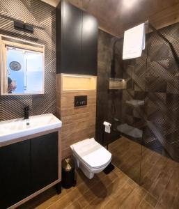 une salle de bain avec un lavabo et des toilettes dans l'établissement Zacisze Mazurskie, à Ryn