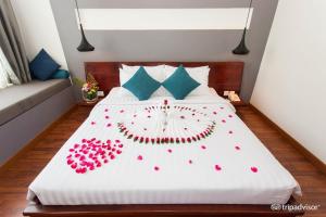 a bed with red flowers on it in a room at Siem Reap Tevi Residence in Siem Reap