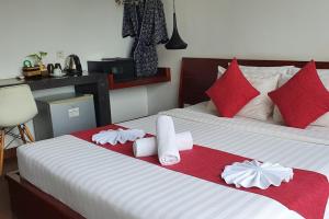 1 dormitorio con 2 camas y toallas rojas y blancas en Siem Reap Tevi Residence, en Siem Reap