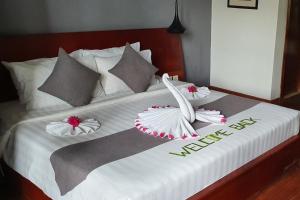 a bed with two white birds on top of it at Siem Reap Tevi Residence in Siem Reap