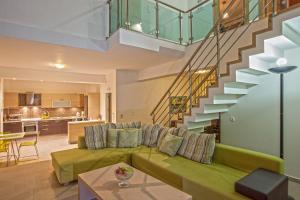 salon z zieloną kanapą i schodami w obiekcie Salvia Villas w mieście Skouloúfia