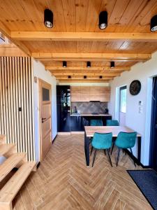 une cuisine et une salle à manger avec une table et des chaises dans l'établissement Zacisze Mazurskie, à Ryn