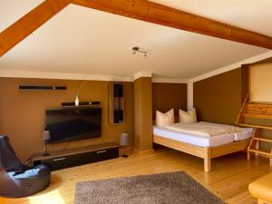 a bedroom with a bed and a flat screen tv at Naturcamp Duvendiek Häuschen in Niepars