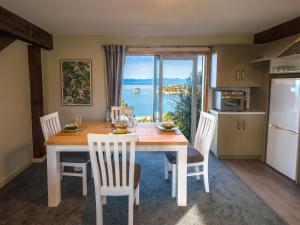a kitchen and dining room with a table with a view at Roydon's Flat - Kaiteriteri Downstairs Unit in Kaiteriteri