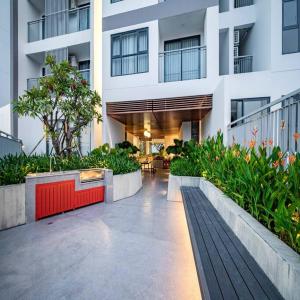 un gran edificio blanco con un patio con plantas en Hoa's lovely 2-bedroom condo with pool, en Ấp Phú Thọ