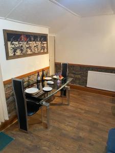 a dining room with a table with chairs and a painting at Carn View Located Nr Heartlands & Carn Brea in Pool