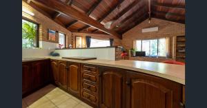 duża kuchnia z drewnianymi szafkami i blatem w obiekcie Kirei Pearl Accommodation Broome w mieście Broome