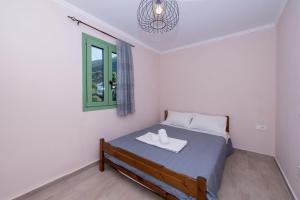 a bedroom with a bed and a window at Mariettas Cottage in Pigadhákia +20 photos