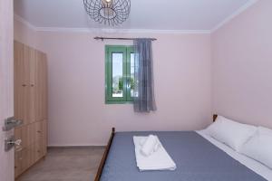 a bedroom with a bed with a green window at Mariettas Cottage in Pigadhákia