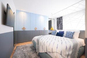a bedroom with a bed with blue and white sheets at 11 11 Apartment Zadar in Zadar