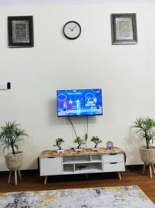 a living room with a tv on a white wall at HoneyLa Homestay Kota Bharu in Kota Bharu