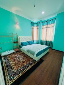 a bedroom with blue walls and a bed with a rug at HoneyLa Homestay Kota Bharu in Kota Bharu