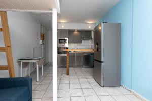 a small kitchen with a refrigerator in a room at Studio Seignosse proche plage in Seignosse