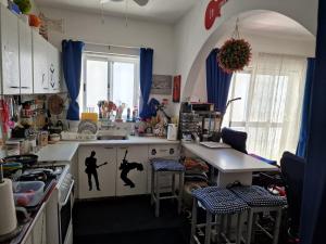 a kitchen with a counter with two people on it at Single room for one person only 5 Minutes walk to Mellieha Bay Beach in Mellieħa