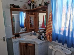 a bathroom with a sink and a mirror and a toilet at Single room for one person only 5 Minutes walk to Mellieha Bay Beach in Mellieħa
