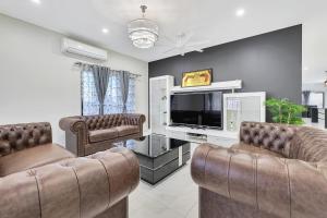 sala de estar con 2 sillas y TV de pantalla plana en Ravi’s Home, en Berrimah