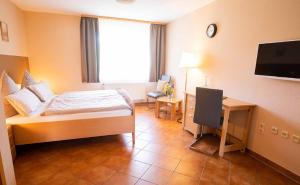 a bedroom with a bed and a desk and a television at Landgasthaus Steffes Hof in Bad Berleburg +15 photos