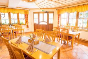 a dining room with wooden tables and chairs at Landgasthaus Steffes Hof in Bad Berleburg