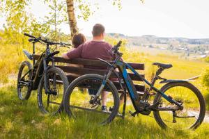 a man and a woman sitting on a bench with bikes at Landgasthaus Steffes Hof in Bad Berleburg