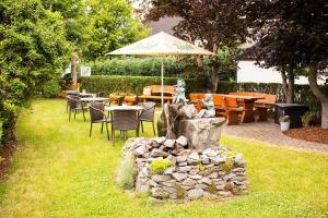 a stone fountain in a yard with tables and chairs at Landgasthaus Steffes Hof in Bad Berleburg