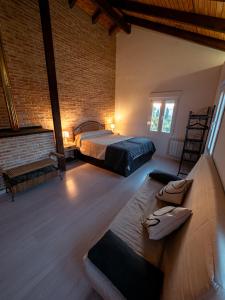 a bedroom with two beds and a brick wall at Casa Rural La Molina 4* in Navamorcuende