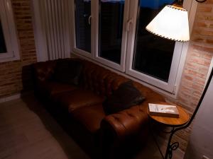 a brown leather couch in a living room with a lamp at Casa Rural La Molina 4* in Navamorcuende