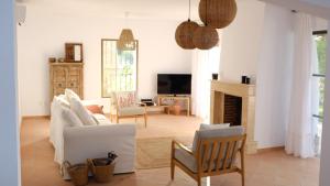 sala de estar con muebles blancos y chimenea en Villa Tropical Dream, en Salobreña
