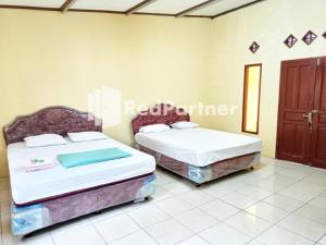 Säng eller sängar i ett rum på Hotel Anita Baturaden Mitra RedDoorz