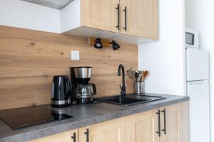 Il comprend une cuisine équipée d'un évier et d'une cafetière. dans l'établissement Studio Elément - Feu, à Saint-Aignan 4 autres photos