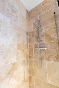 une douche avec un tuyau dans une salle de bain dans l'établissement Studio Elément - Feu, à Saint-Aignan