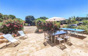 eine Terrasse mit Tisch und Stühlen und einem Sonnenschirm in der Unterkunft Cozy Home In Saint-Jean-De-Minervoi in Saint-Jean-de-Minervois + 18 Fotos