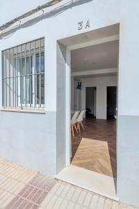 uma porta aberta de um edifício branco com uma sala de jantar em Algaba aral em Alcalá del Río