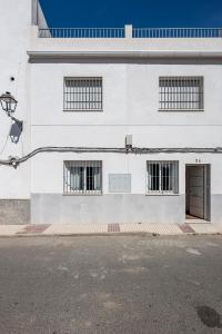 un edificio blanco con 4 ventanas y una puerta en Algaba aral en Alcalá del Río