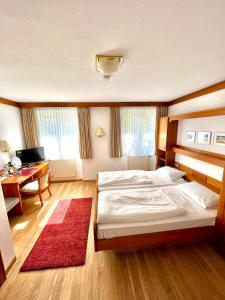 ein Schlafzimmer mit einem großen Bett und einem Schreibtisch in der Unterkunft Hotel Krone in Neuenburg am Rhein