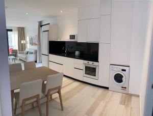 a kitchen with a table and chairs and a washing machine at AZAHAR BEACH Red Apartments & Spa in Alcossebre
